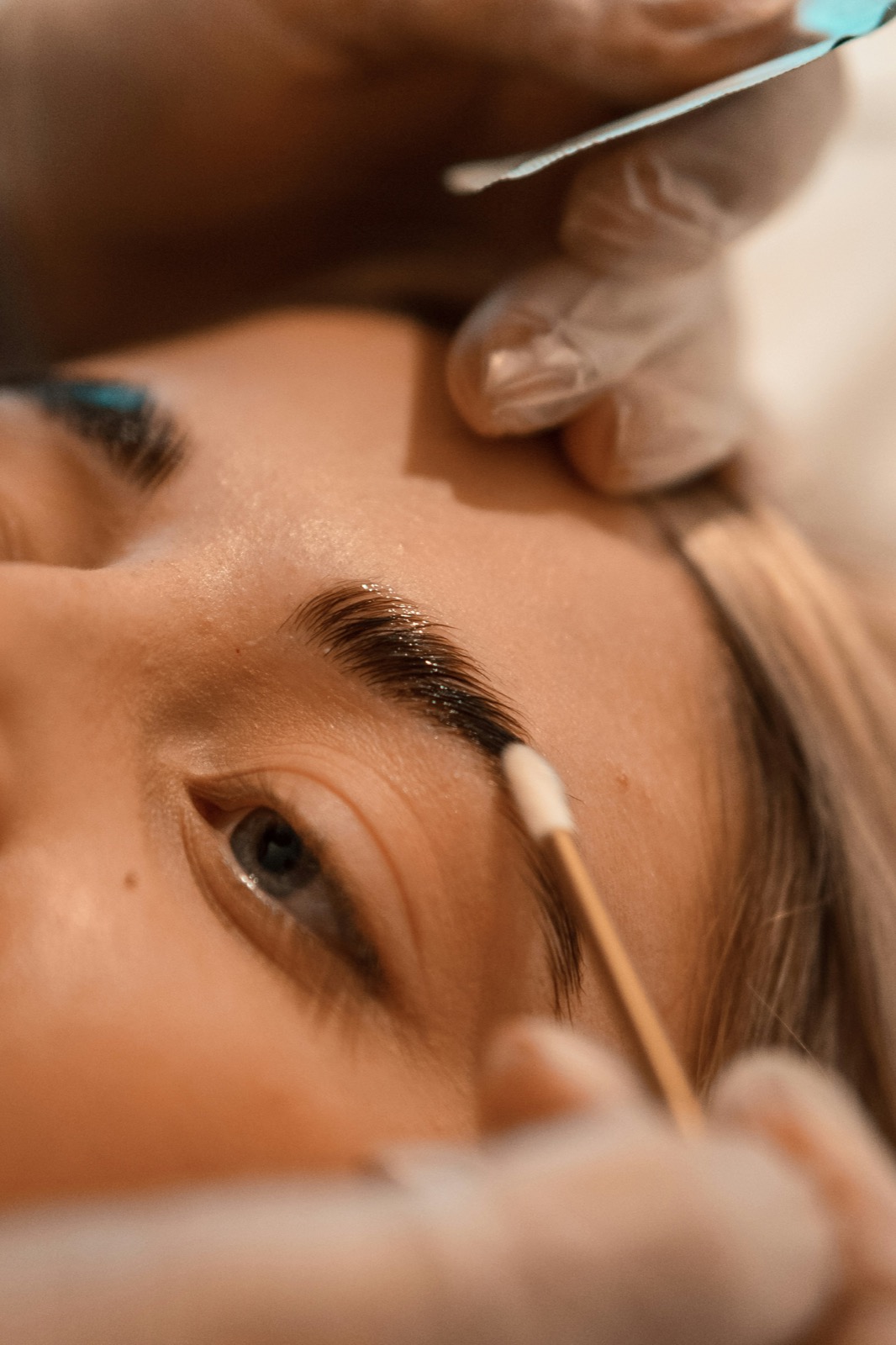 An esthetician applying a brow lamination treatment